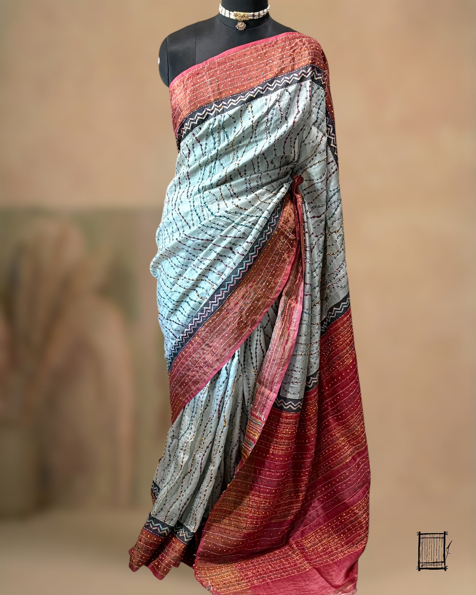  The body of this sophisticated grey saree features unique wavy Kantha lines that mimic the flow of water. 